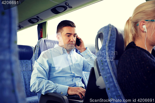 Image of man with smartphone and laptop in travel bus