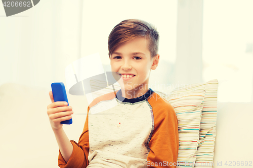 Image of boy with smartphone texting or playing at home