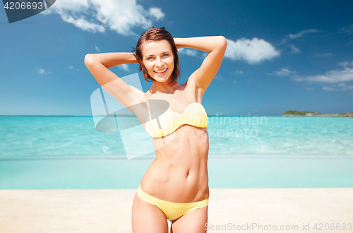 Image of happy woman in bikini swimsuit on tropical beach