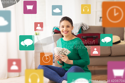 Image of happy woman with money and travel bag at home