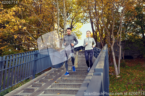 Image of happy couple running downstairs in city