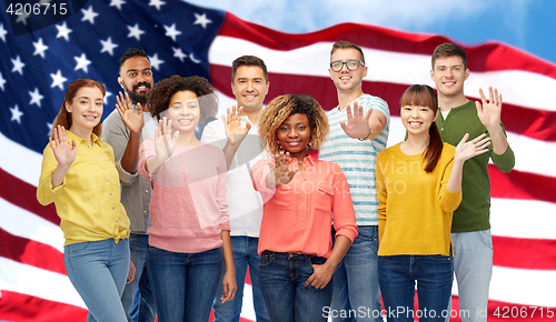 Image of international group of happy people waving hand