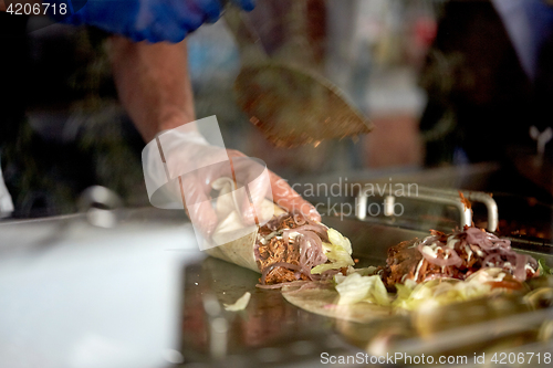 Image of cook cooking tortilla wraps at street market