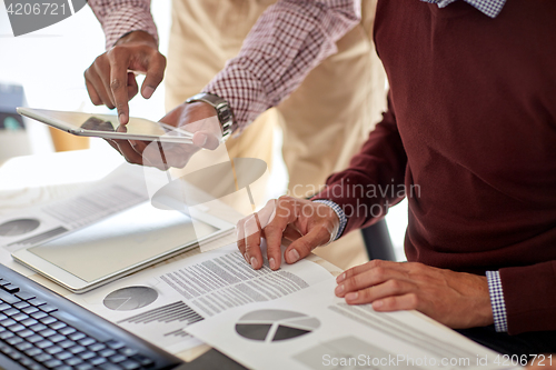 Image of businessmen with tablet pc and charts at office