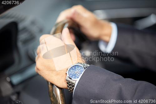 Image of senior businessman hands driving car