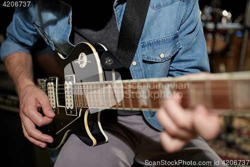 Image of man playing guitar at studio rehearsal