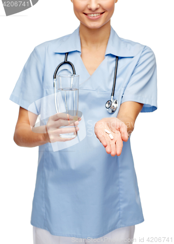 Image of smiling doctor or nurse offering pills and water