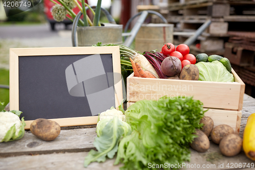 Image of close up of vegetables with chalkboard on farm