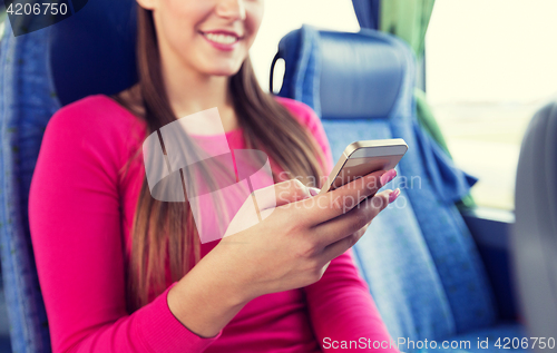 Image of close up of woman in travel bus with smartphone