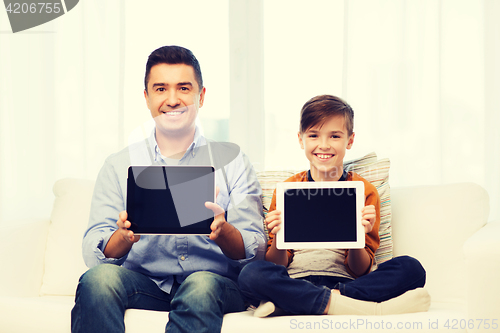 Image of happy father and son with tablet pc at home