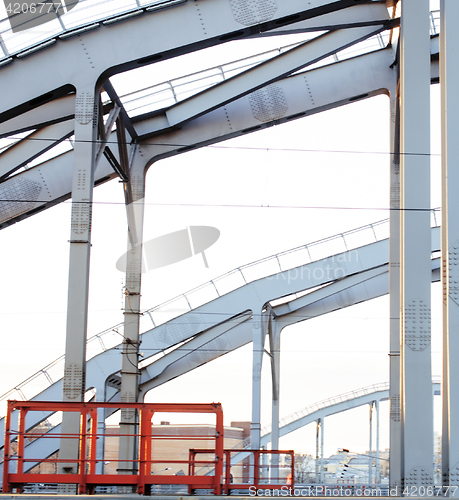 Image of landscape with railway with trains, lot of steel rafters at sunset 