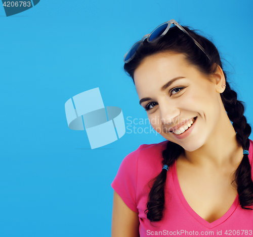 Image of young pretty teenage modern hipster girl posing emotional happy smiling on blue background, lifestyle people concept 