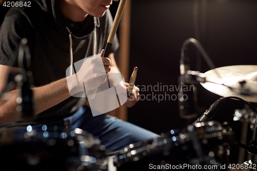 Image of male musician playing drums and cymbals at concert