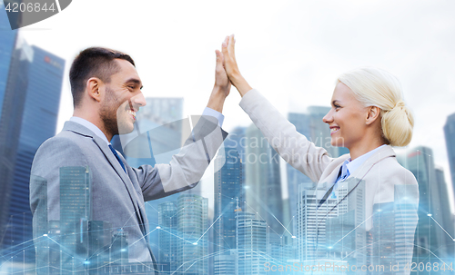 Image of businessman and businesswoman making high five