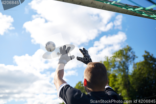 Image of goalkeeper with ball at football goal on field