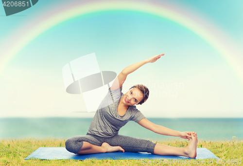 Image of happy woman making yoga and stretching on mat