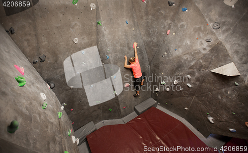 Image of young woman exercising at indoor climbing gym