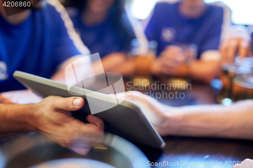 Image of soccer fans or friends with tablet pc at sport bar