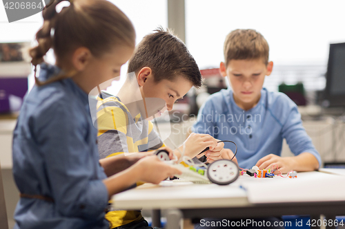 Image of happy children building robots at robotics school