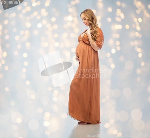 Image of happy pregnant woman touching her big belly