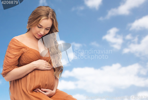 Image of happy pregnant woman touching her big belly