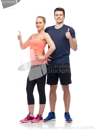 Image of happy sportive man and woman showing thumbs up