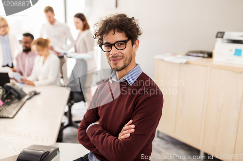 Image of happy young man over creative team in office