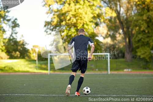 Image of soccer player playing with ball on football field