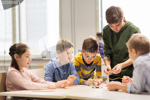 Image of happy children building robots at robotics school