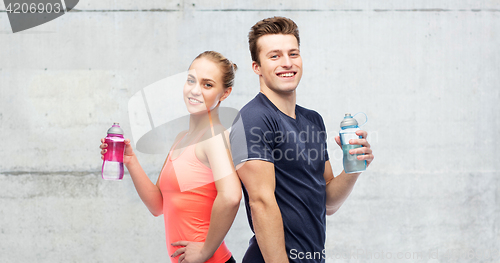 Image of sportive man and woman with water bottles