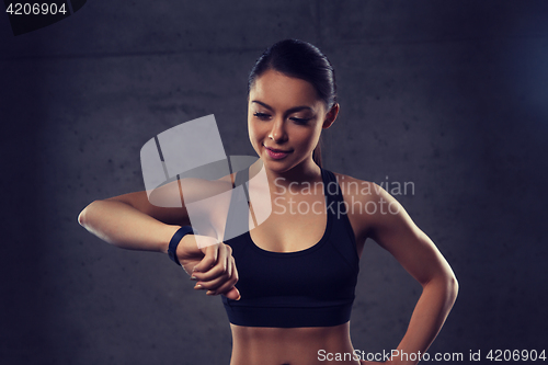 Image of young woman with heart-rate watch in gym