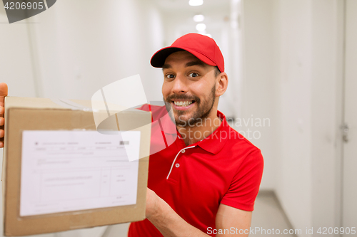 Image of delivery man with parcel box in corridor