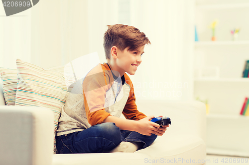 Image of happy boy with joystick playing video game at home