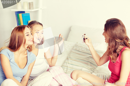 Image of teen girls with smartphone taking picture at home