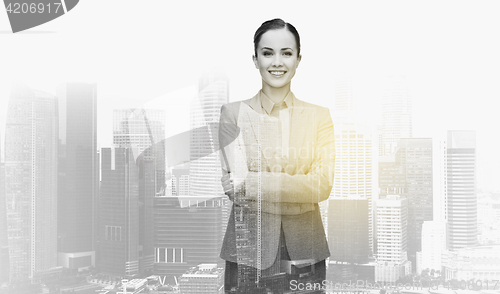 Image of smiling businesswoman over city buildings