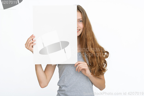 Image of Young smiling woman show blank card or paper