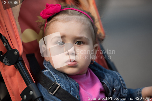 Image of baby girl sitting in the pram