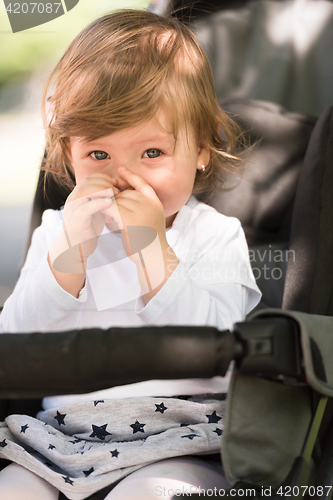 Image of baby girl sitting in the pram