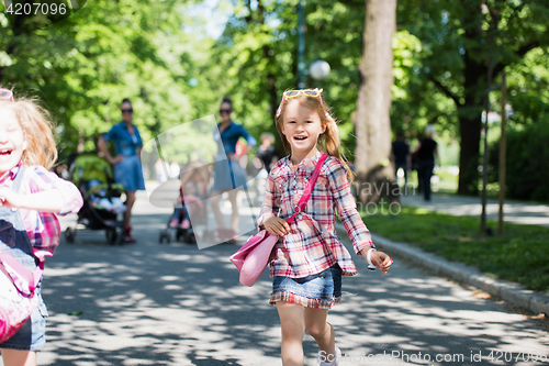 Image of twins mother with children  in city park