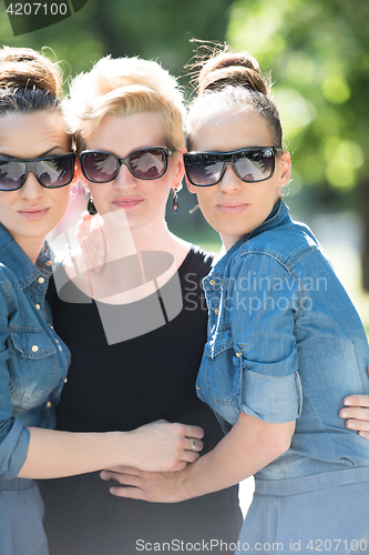 Image of portrait of three young beautiful woman with sunglasses