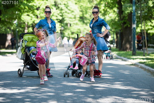 Image of twins mother with children  in city park