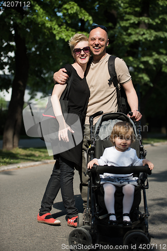 Image of couple with baby pram in summer park