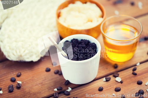 Image of close up of coffee scrub in cup and honey on wood