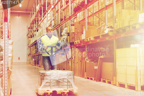 Image of man carrying loader with goods at warehouse