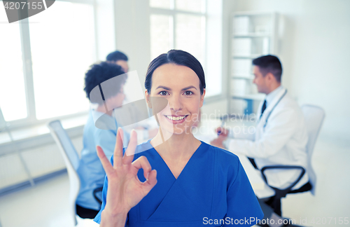 Image of happy doctor over group of medics at hospital