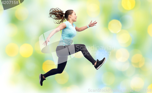 Image of happy smiling sporty young woman jumping in air