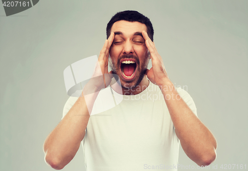 Image of crazy shouting man in t-shirt over gray background