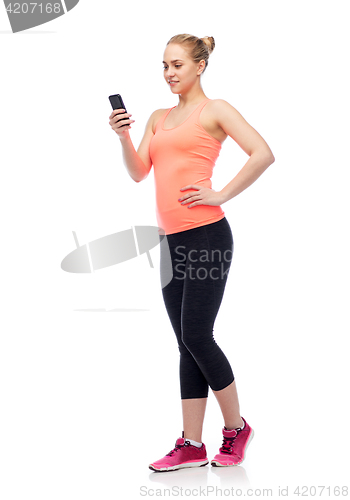 Image of happy smiling sportive young woman with smartphone