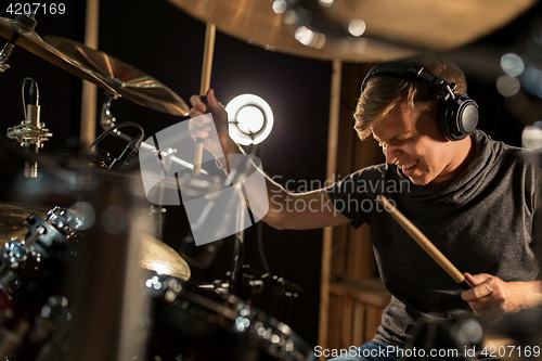 Image of male musician playing drums and cymbals at concert