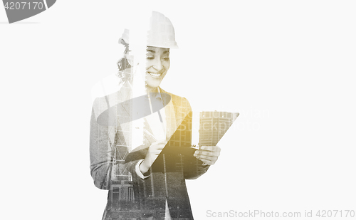 Image of businesswoman in building helmet with clipboard